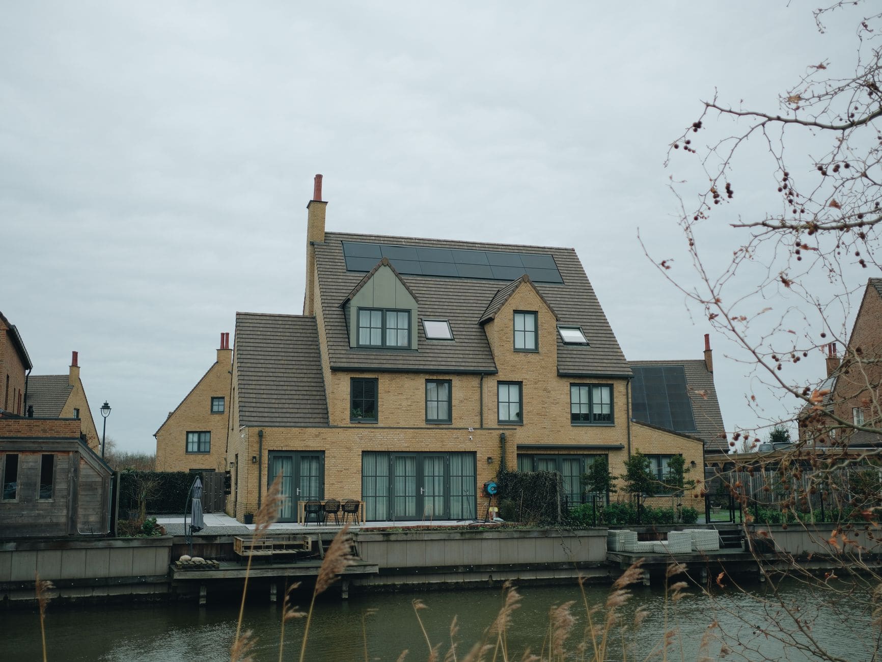 Brick houses beside a canal, solar panels on two roofs